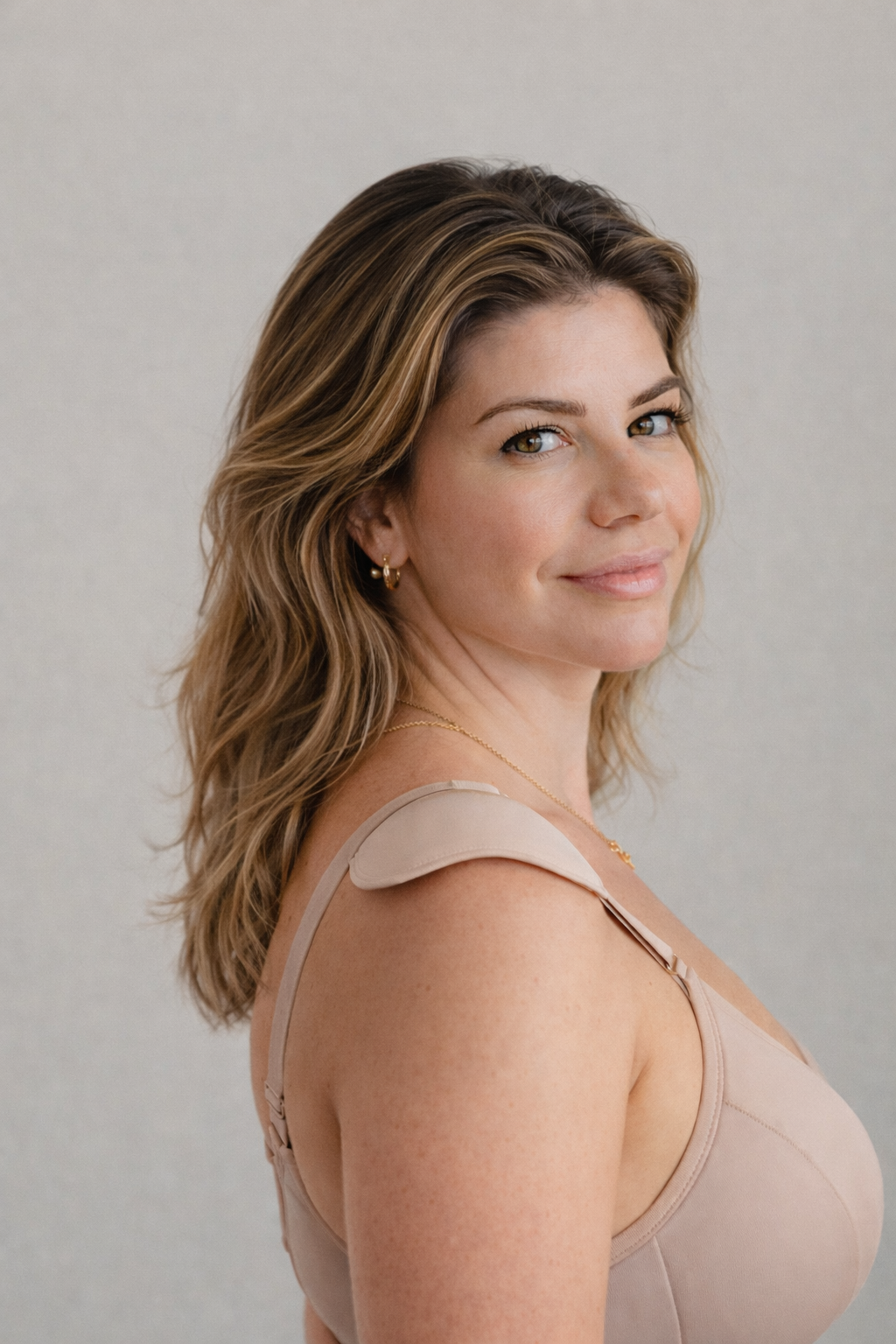 Side view of woman wearing a Gloris removable shoulder shaper under her bra strap