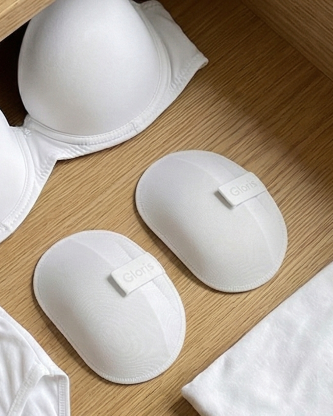 White Gloris removable shoulder shapers beside white bras and lingerie